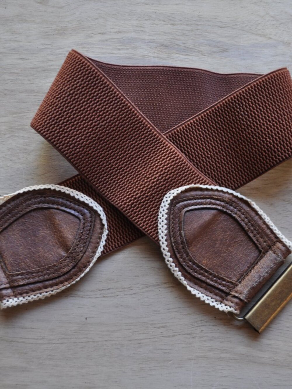 Women's brown elastic stretch belt features brown faux leather panels accented w